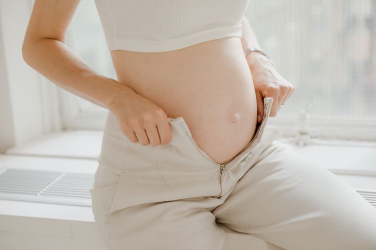 žena pokazuje stomak u ranoj trudnoći